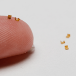 micro-size telemedicine brass components next to a finger to show size portions